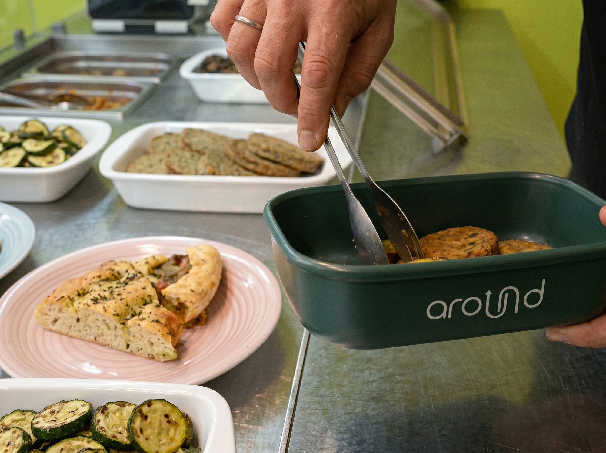 Contenitore riutilizzabile con cibo pronto su banco/tavolo.